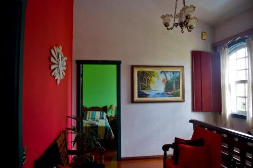 um corredor com uma porta verde num quarto em Pousada do Getulio em Tiradentes