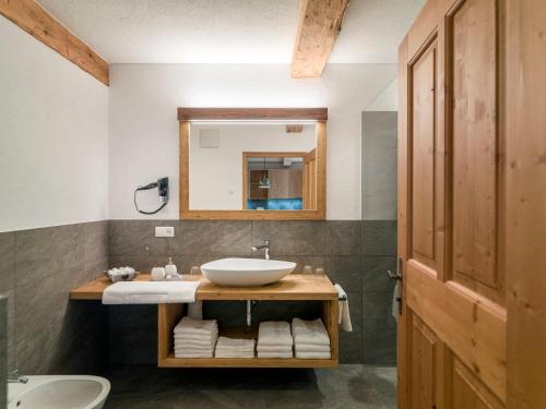 uma casa de banho com um lavatório e um espelho em Bruggerhof Prags em Braies (Prags)
