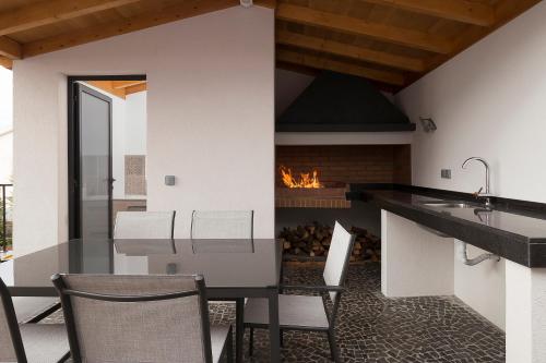 a kitchen with a fireplace and a table and chairs at Villa Guiné in Arco da Calheta