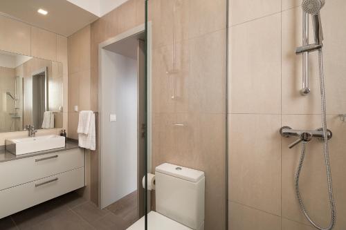 a bathroom with a shower and a toilet and a sink at Villa Guiné in Arco da Calheta