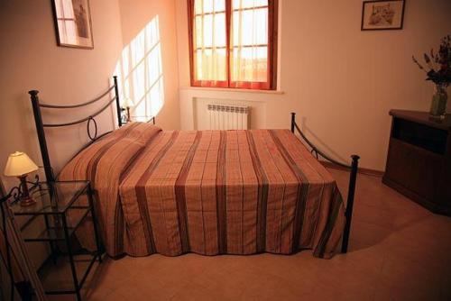 
a bedroom with a bed and a window at Residence Podere Olmo in Sovicille
