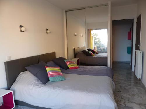 a bedroom with two beds and a large mirror at LE JAD, ROQUEBRUNE in Roquebrune-Cap-Martin