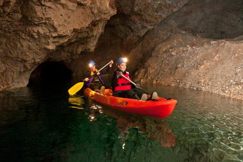 two people in a red kayak in a cave at Apartmaji Koželj in Ribnica na Pohorju