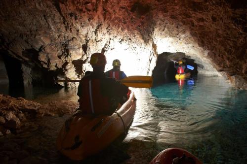 a group of people in a kayak in a cave at Apartmaji Koželj in Ribnica na Pohorju