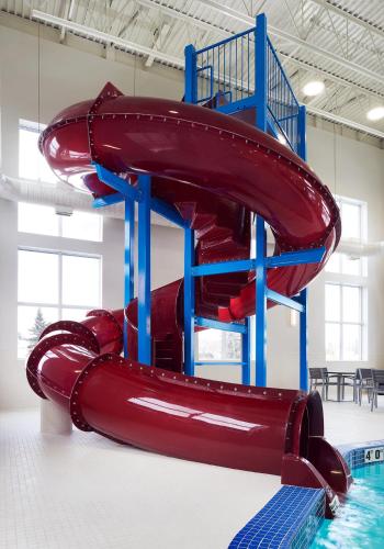 a red water slide in a room with a pool at Best Western Plus Edmonton Airport Hotel in Leduc
