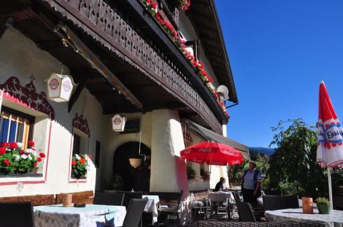 a restaurant with tables and a red umbrella at Gasthof Neuwirt in Ellbögen