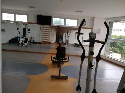 a gym with cardio equipment in a room with windows at Jardim Armação Salvador in Salvador