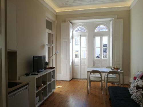 a living room with a table and chairs and a window at Ah33 - Estúdios in Coimbra