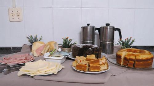 a table topped with different types of bread and cheese at La Villa Hotel in Cordeirópolis