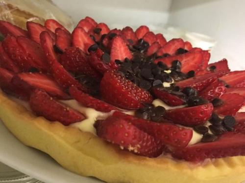 a fruit pizza with strawberries and chocolate on a plate at Hotel Eremo in Soriano nel Cimino