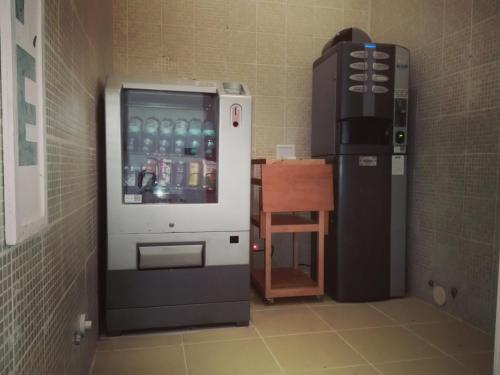 a drink machine in a room next to a table at Birilli B&B in Civitanova Marche