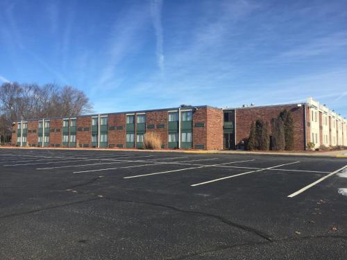 an empty parking lot in front of a brick building at Mystic River Hotel & Suites in Mystic