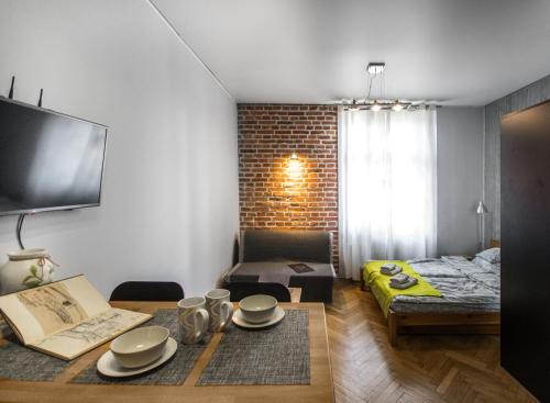 a living room with a table with plates on it at Lost In Krakow Apartments in Krakow