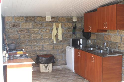 cocina con pared de ladrillo, fregadero y fogones en Hotel-complex Mizh Triokh Ozer en Svityazʼ