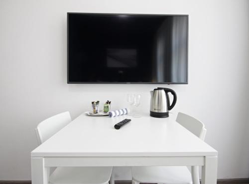 a table with a tv and a coffee mug on it at Alveo Suites in Prague