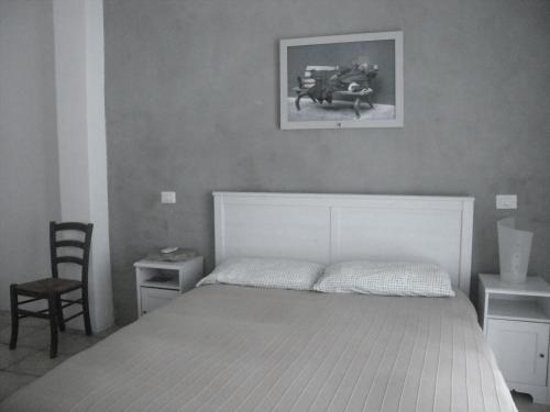 ナポリにあるLa Casaforte art residencyのベッドルーム1室(壁に絵が描かれた白いベッド1台付)