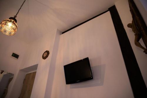 uma televisão de ecrã plano numa parede branca com um relógio em Luky 12 em Brasov