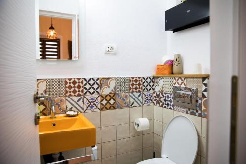 ein Badezimmer mit einem gelben Waschbecken und einem WC in der Unterkunft Luky 12 in Braşov