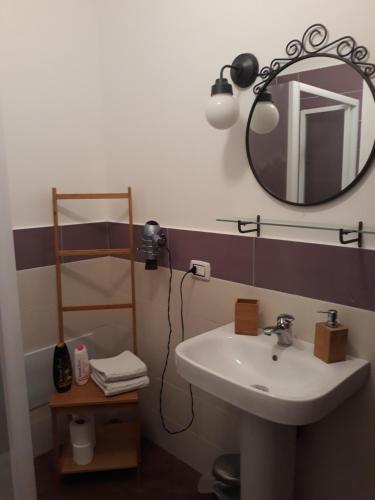 a bathroom with a sink and a mirror at Pirtuso Del Porto in Palermo