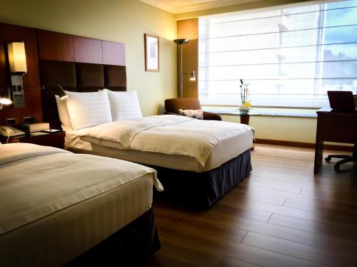 a hotel room with two beds and a window at Swissotel Quito in Quito