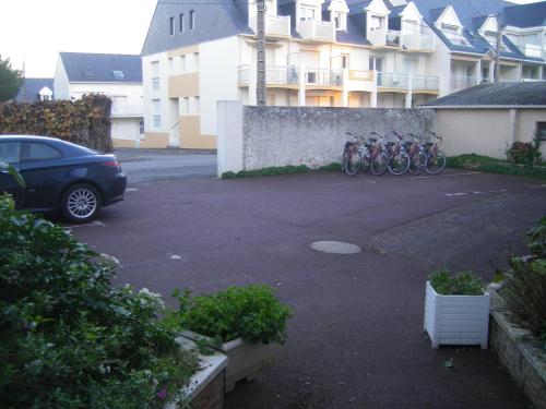 a parking lot with bikes parked next to a building at Les Chants d'Ailes - Hôtel Face Mer in La Turballe