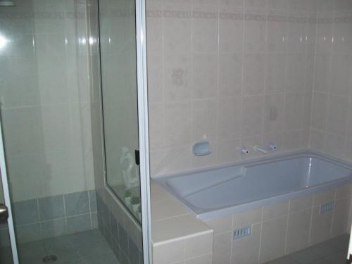a bathroom with a bath tub and a shower at Mainsail 10 17 Owen Street in Port Macquarie
