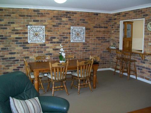 a dining room with a table and chairs and a brick wall at Mainsail 10 17 Owen Street in Port Macquarie