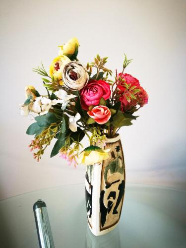 a vase filled with flowers sitting on a table at Belmont Motor Inn in Christchurch
