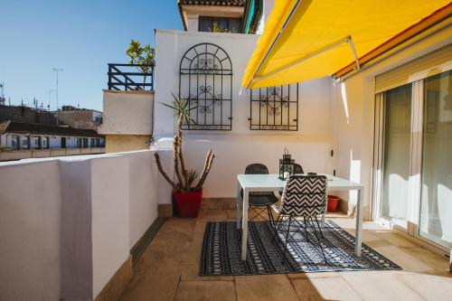 a patio with a table and chairs on a balcony at Reyes 59 in Granada