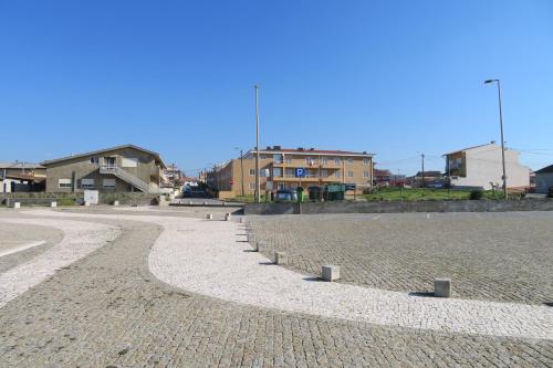 a cobble stone street with houses in the background at Lenda do Mar in Vila Chã