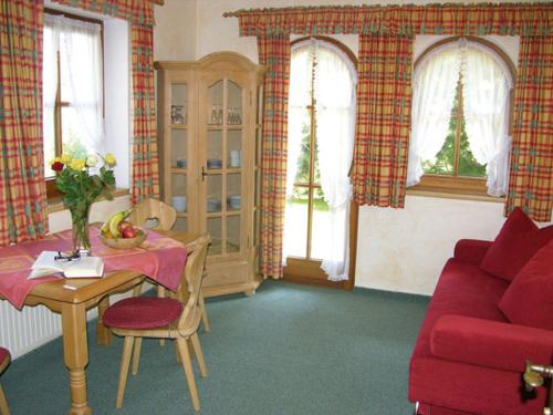 a living room with a red couch and a table at Landhaus Maria in Finkenberg