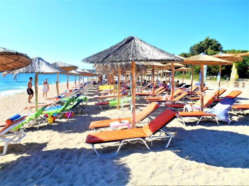 a bunch of chairs and umbrellas on a beach at Mezonetes Toroni in Toroni