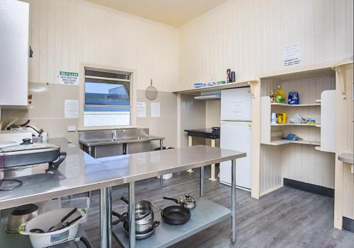 a kitchen with a table and a sink in it at Bunk Inn Hostel in Bundaberg
