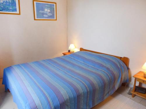 - une chambre avec un lit et une couverture rayée bleue dans l'établissement Holiday Home Le chant des milans by Interhome, à Ondres