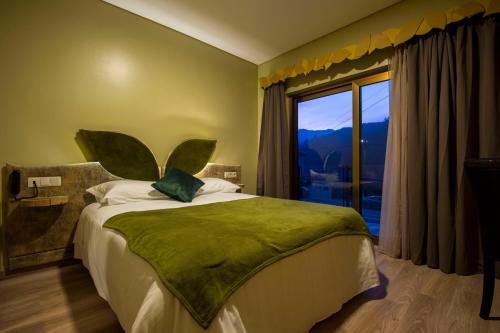 - une chambre avec un grand lit et une grande fenêtre dans l'établissement Beleza Serra Guide Hotel, à Gerês