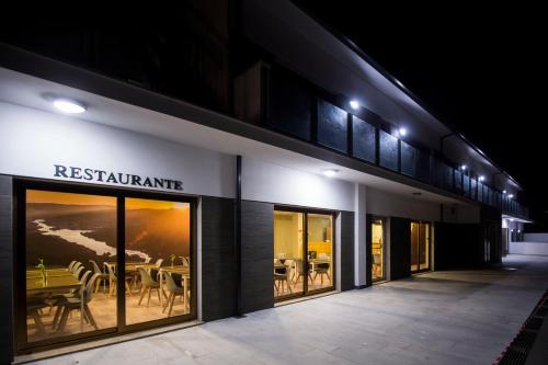 a restaurant with glass doors and tables in a building at Beleza Serra Guide Hotel in Geres