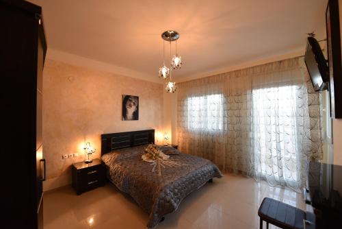 a bedroom with a bed and a large window at Artisti Elena in Paralia Katerinis