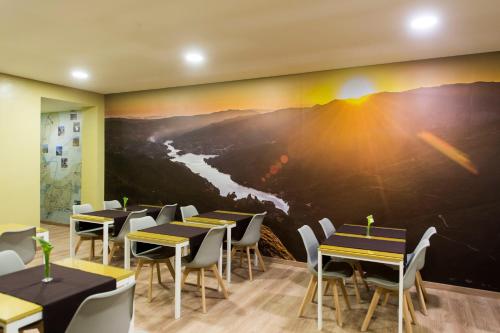 a restaurant with tables and chairs and a painting on the wall at Beleza Serra Guide Hotel in Geres