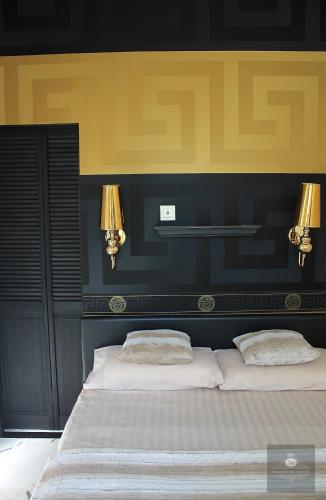 two beds in a bedroom with two lamps on the wall at 'Maison Blanche' in Cannes