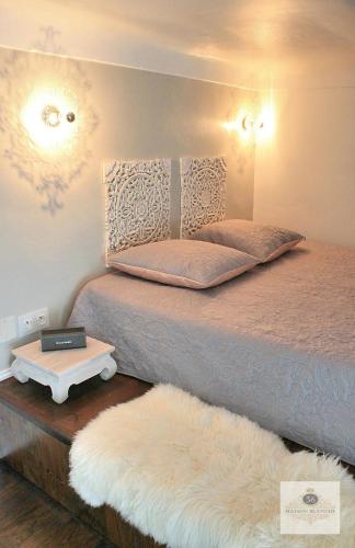 a bedroom with a bed and a table with a white bedspread at 'Maison Blanche' in Cannes