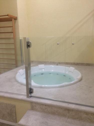 a bathroom with a bath tub with a glass wall at Anitta 2 in Sao Paulo