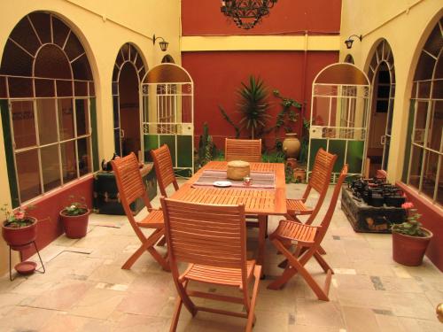 a patio with a wooden table and chairs at Posada Don Giorgio in Puno