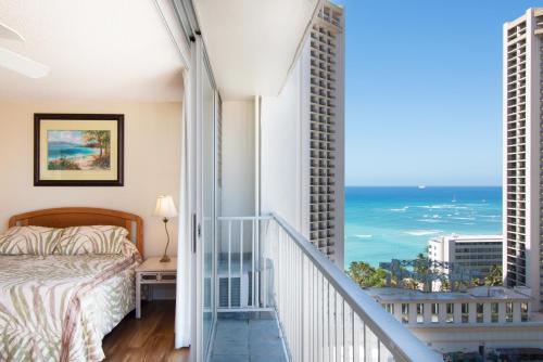 a bedroom with a bed and views of the ocean at Ocean View Studio, Near Waikiki Beach in Honolulu