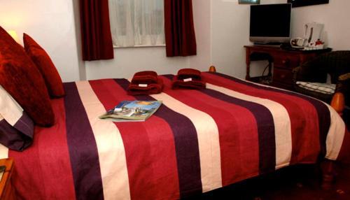 a red and white bed with two bags on it at Adam Place Guest House in Windermere
