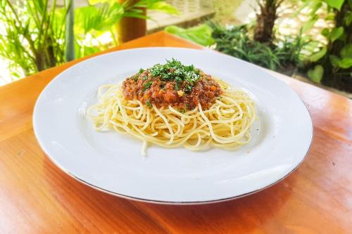a plate of spaghetti with meatballs on a table at Naturela in Uluwatu