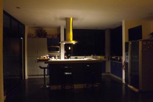 a kitchen with a island with a yellow vent at Casa Marlui-San José in Curridabat