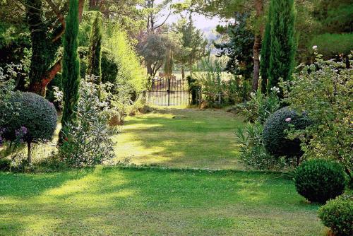 a garden with a gate and some bushes and trees at Le Domaine de Saint Veran in Orgon