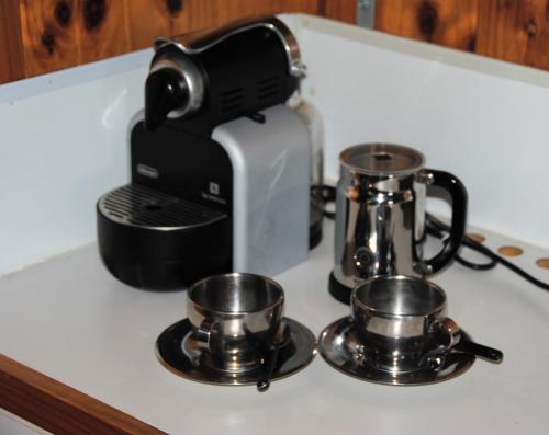 a kitchen counter with a coffee maker and two pans at The Wombat Cottage in Tullah