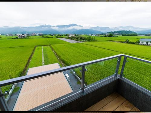 a balcony with a view of a green field at 宜人生活溜滑梯親子民宿 Easylife B&B in Dongshan