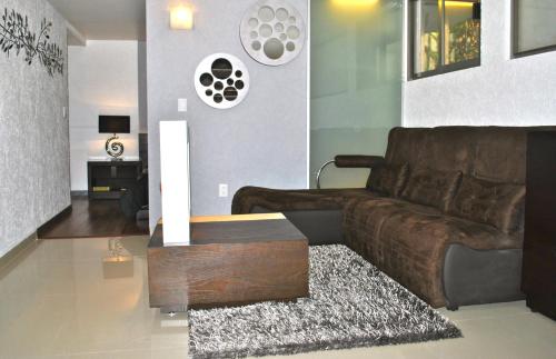 uma sala de estar com um sofá castanho e uma mesa de centro em Business Suites SG em Cidade do México